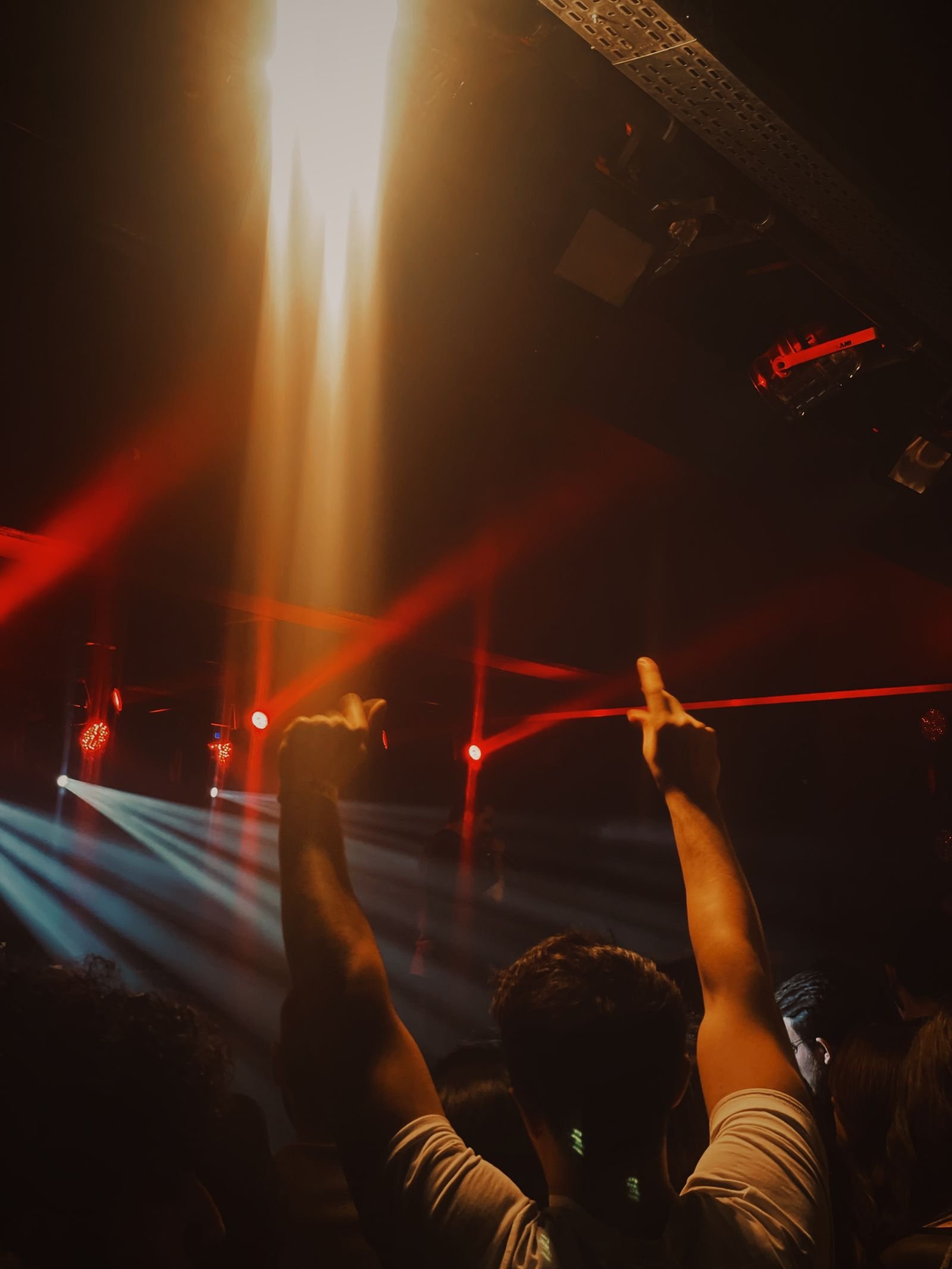 Pista piena sotto i fasci di luce durante una serata in discoteca